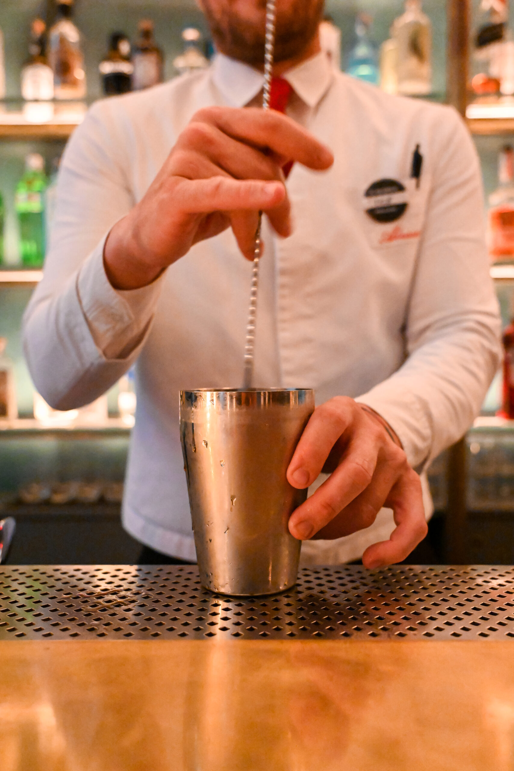 A barkeeper is stirring a drink in a shaker at the COMPANION Dolce Amaro Bar in Florence.