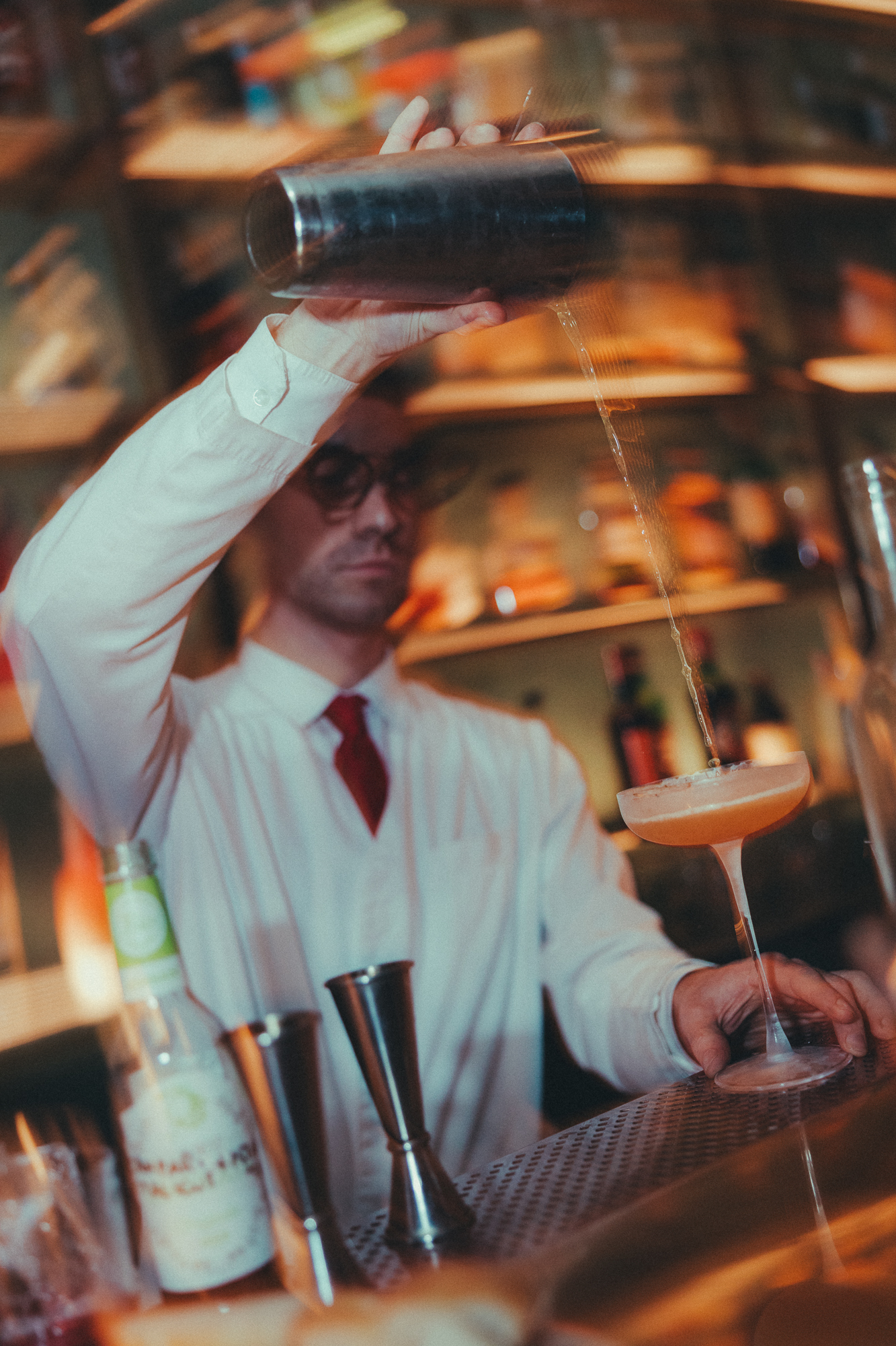 A bartender pouring a drink from the shaker at the Companion Dolce Amaro Bar.